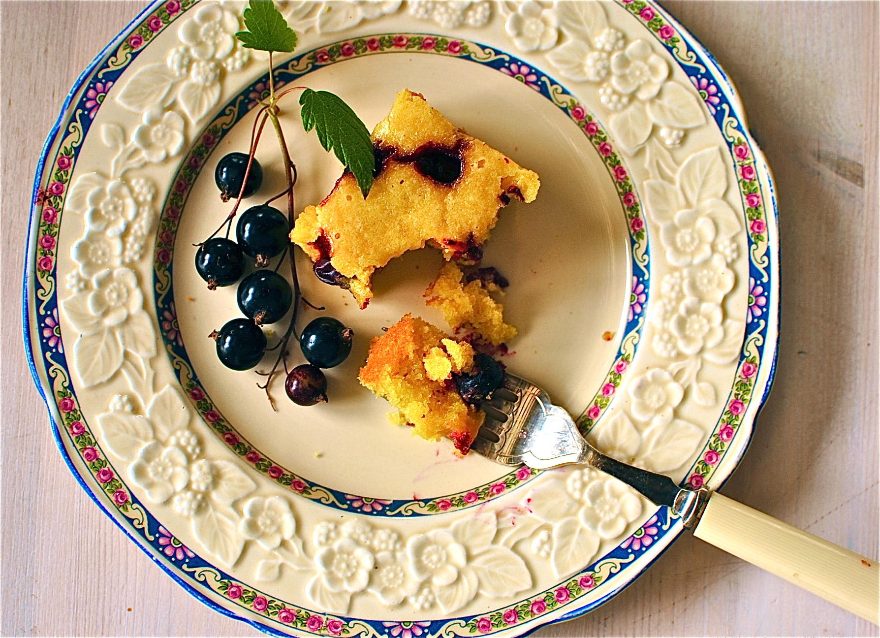a slice of lemon polenta cake on a plate with fresh berries