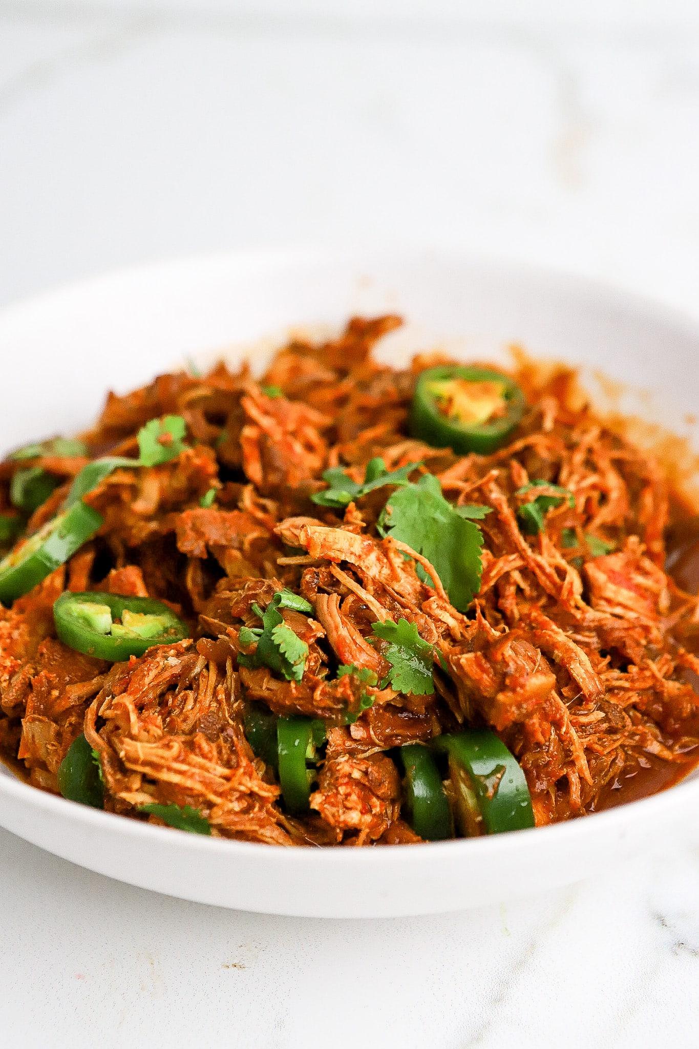 Close-up shot of shredded salsa chicken in a slow cooker