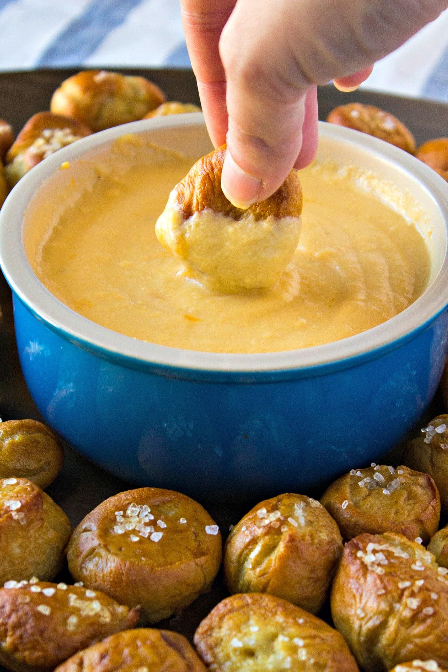 Close-up shot of golden-brown beer pretzel bites with a creamy potato salad dip
