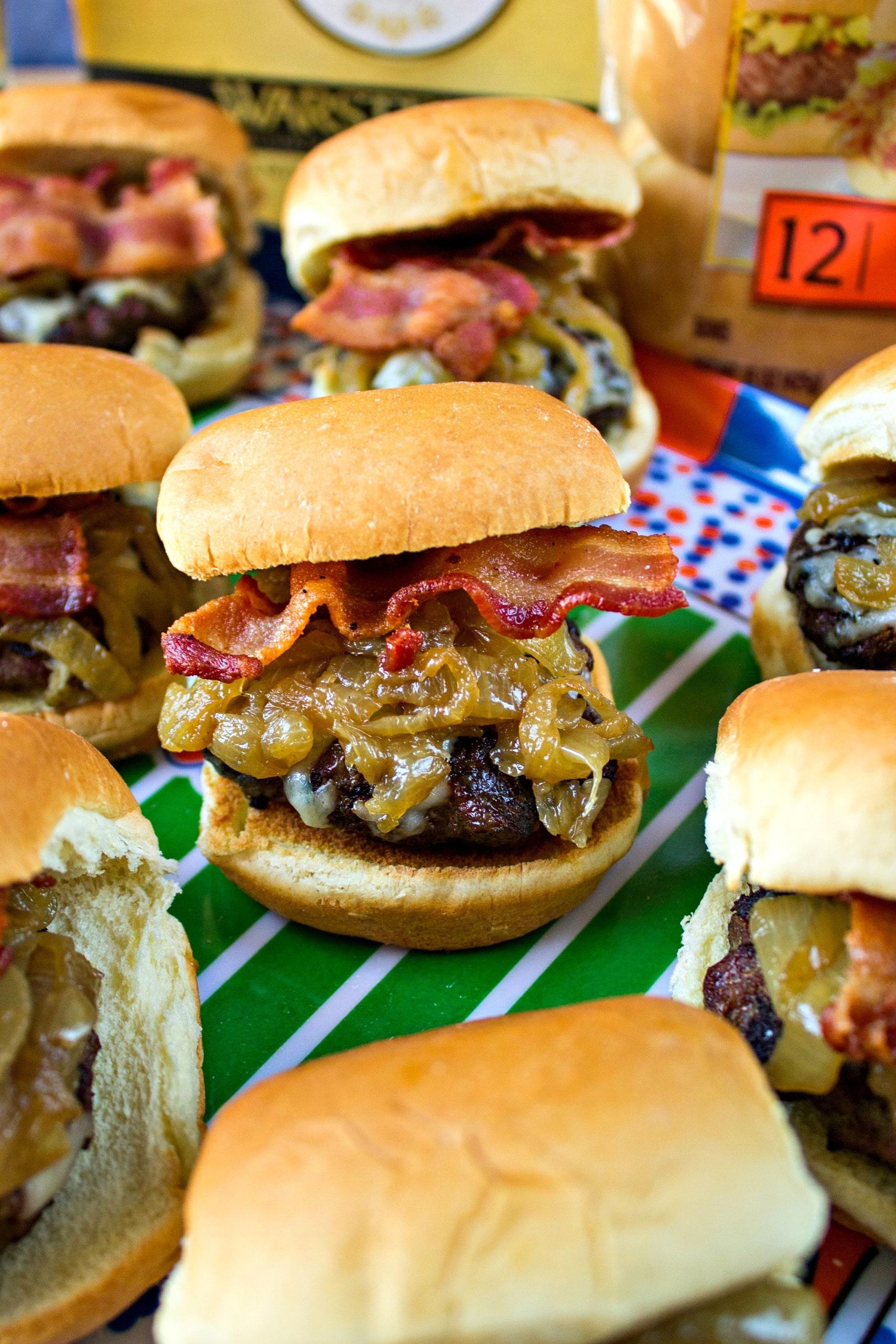 a person assembling sliders with onion jam and gruyere cheese