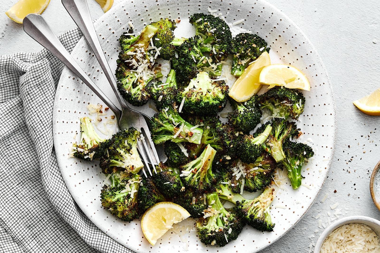 A plate of Garlic Parmesan Roasted Broccoli served as a side dish alongside a main course