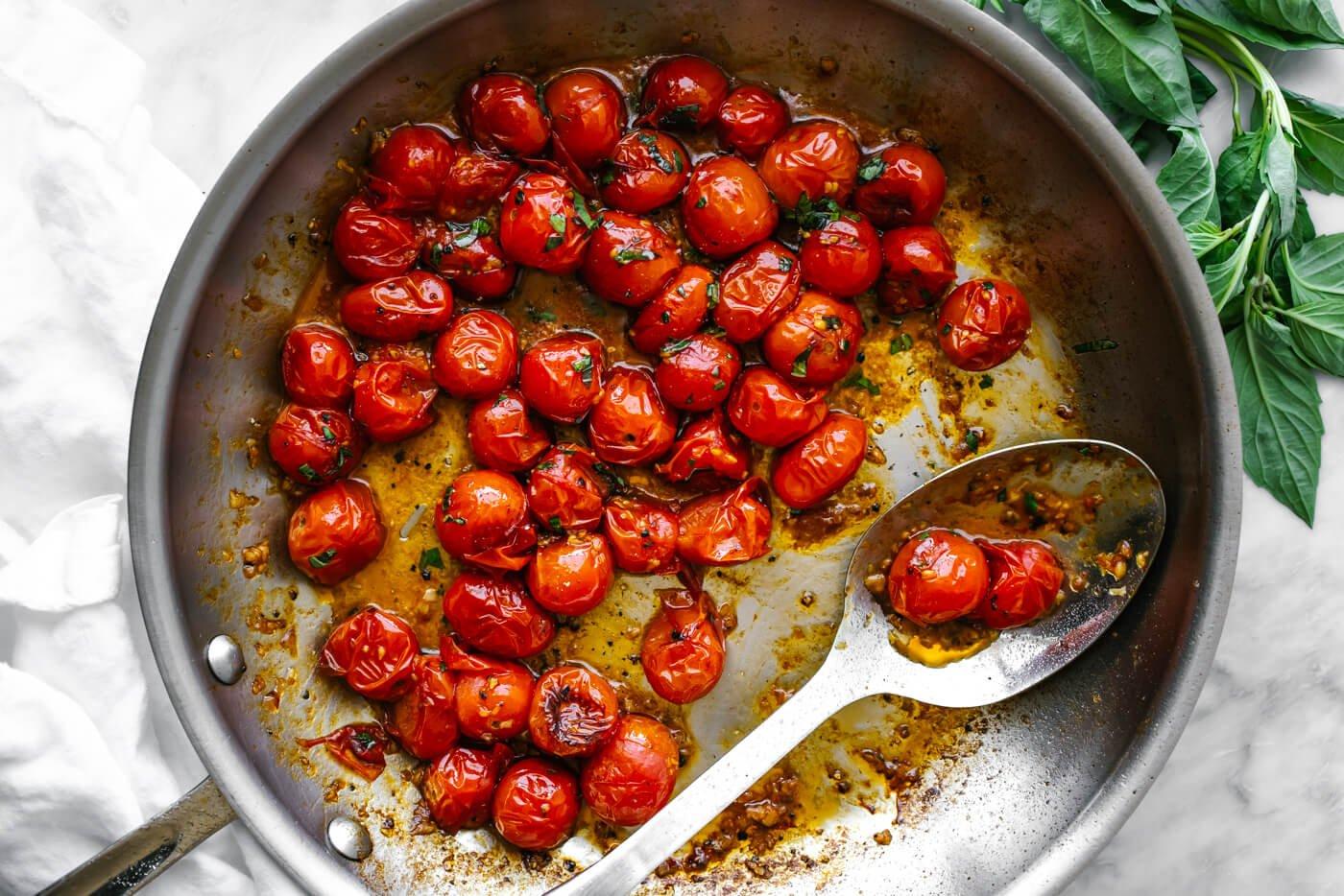 close-up shot of blistered cherry tomatoes on a grill, showing the charred skin and juicy interior