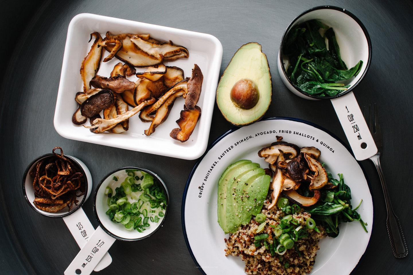 Close-up of a bowl of quinoa salad with shiitake mushrooms and vibrant vegetables