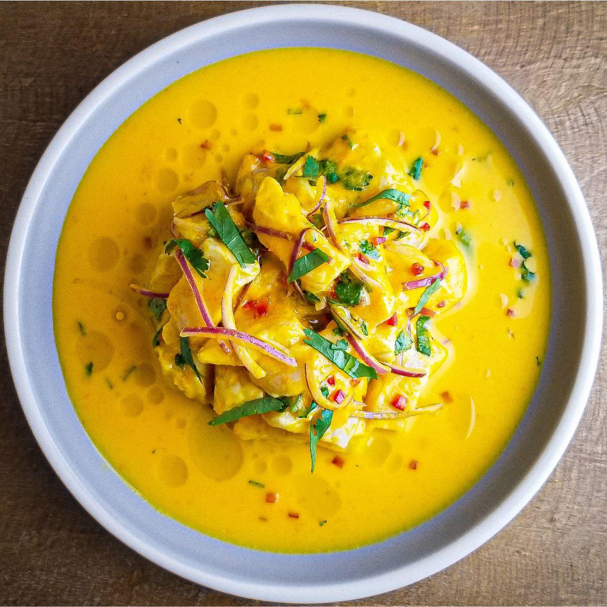 Close-up shot of vibrant ceviche with aji amarillo marinade, garnished with cilantro and red onion