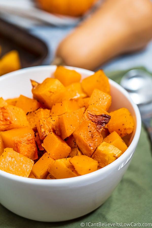 A close-up shot of the roasted butternut squash being scooped into a bowl