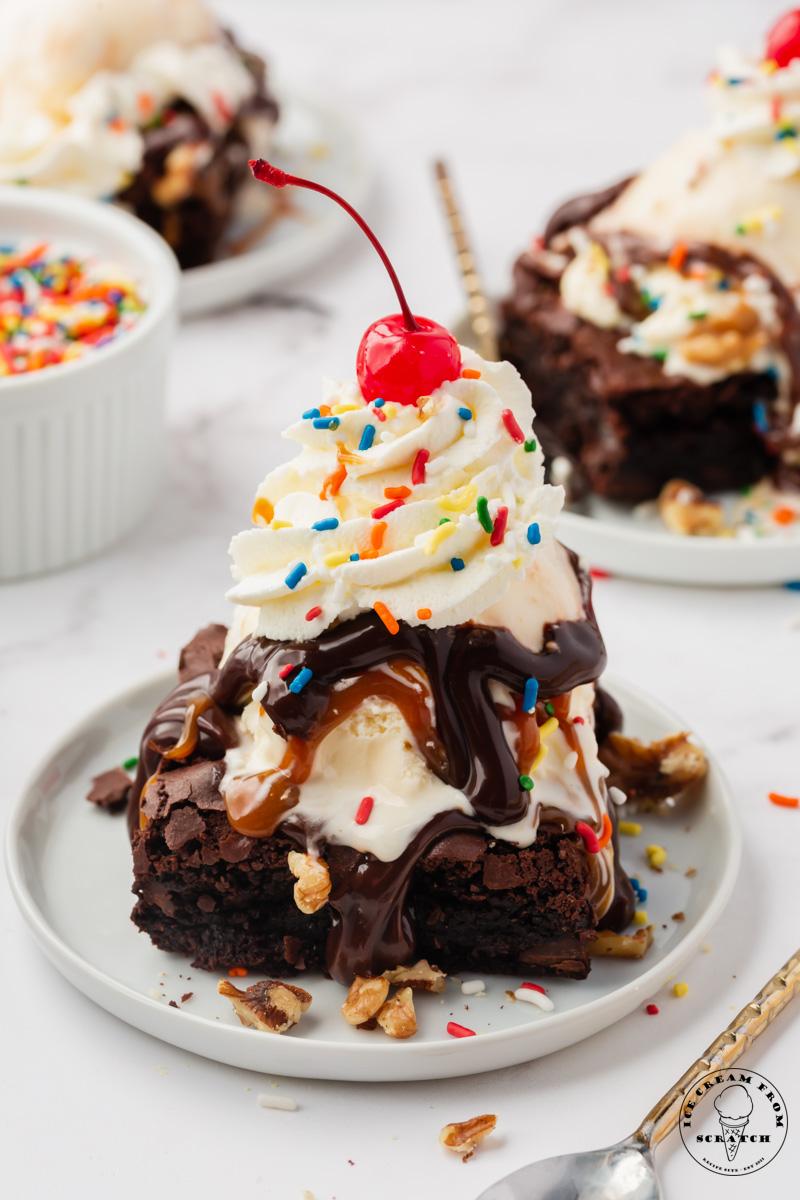 A beautifully styled brownie sundae in a glass, with various toppings