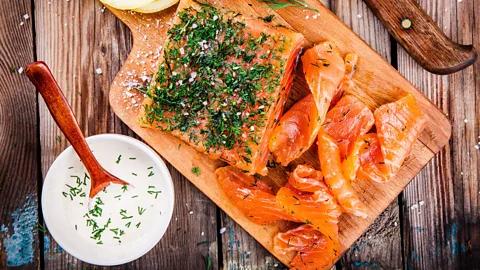 A plate of Gravlax Stuffed Bell Peppers, garnished with fresh dill and a drizzle of creme fraiche