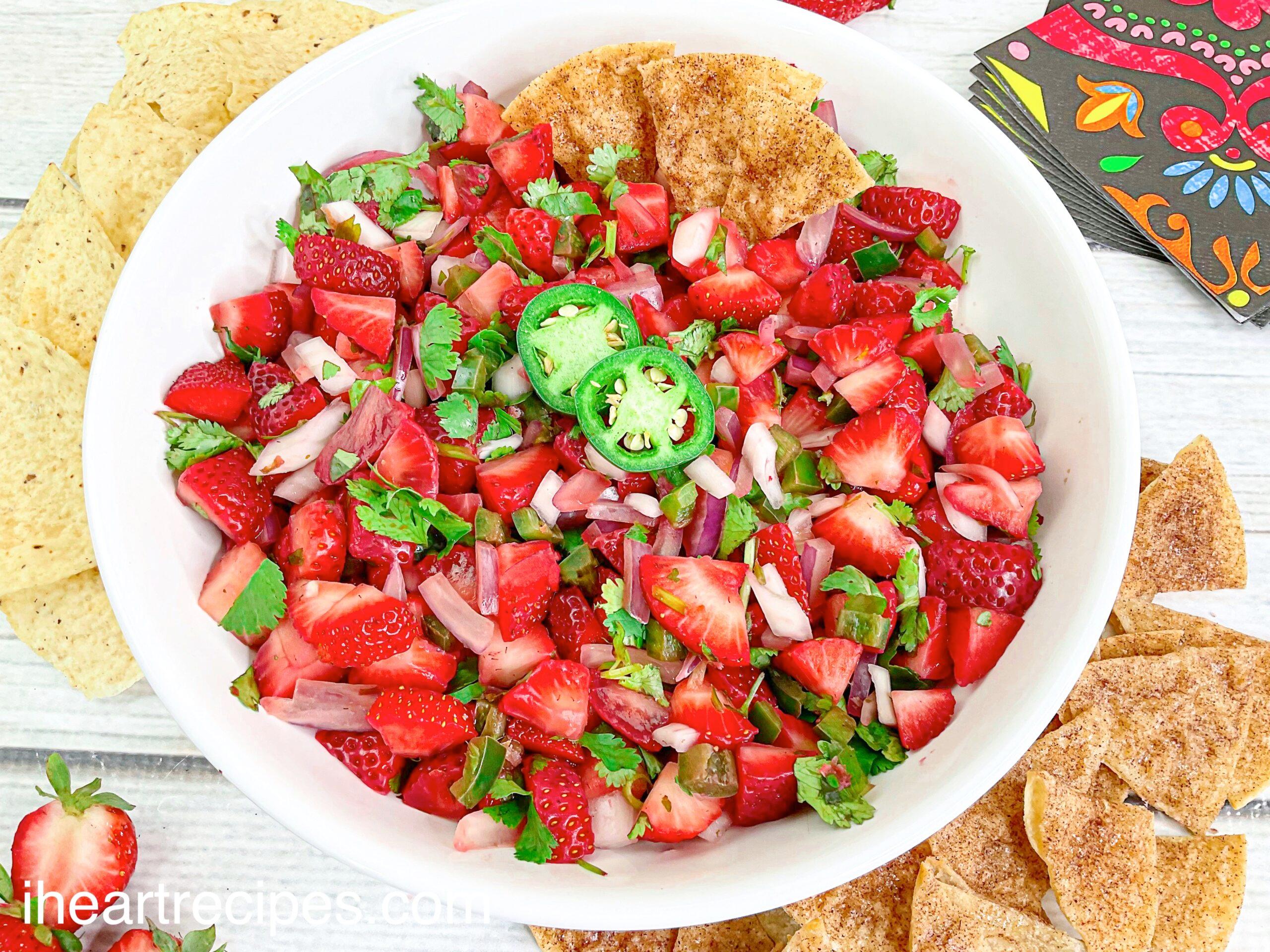 friends enjoying strawberry jalapeno salsa with chips at an outdoor barbecue