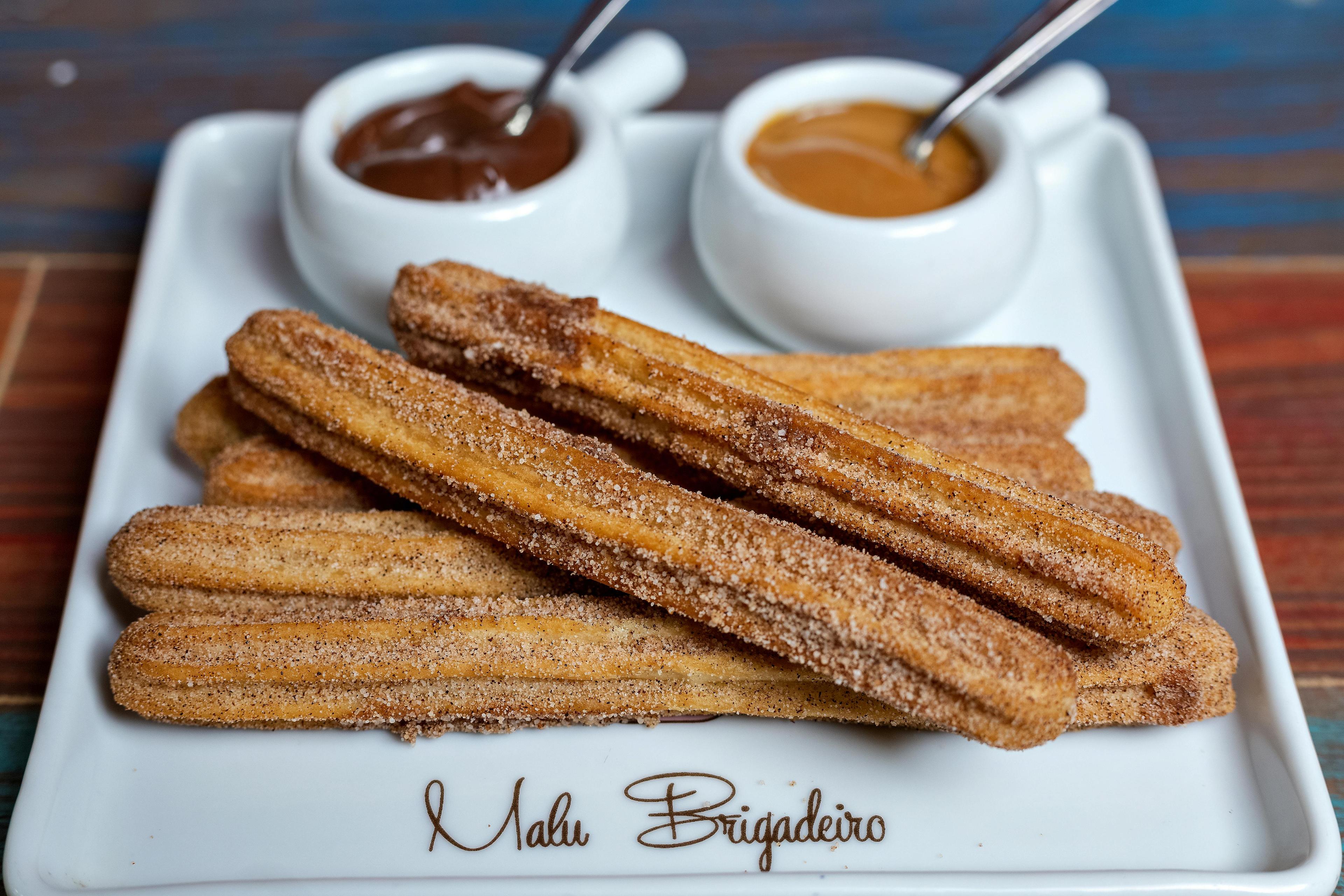 overhead shot of a plate full of raspberry white chocolate churros dusted with powdered sugar