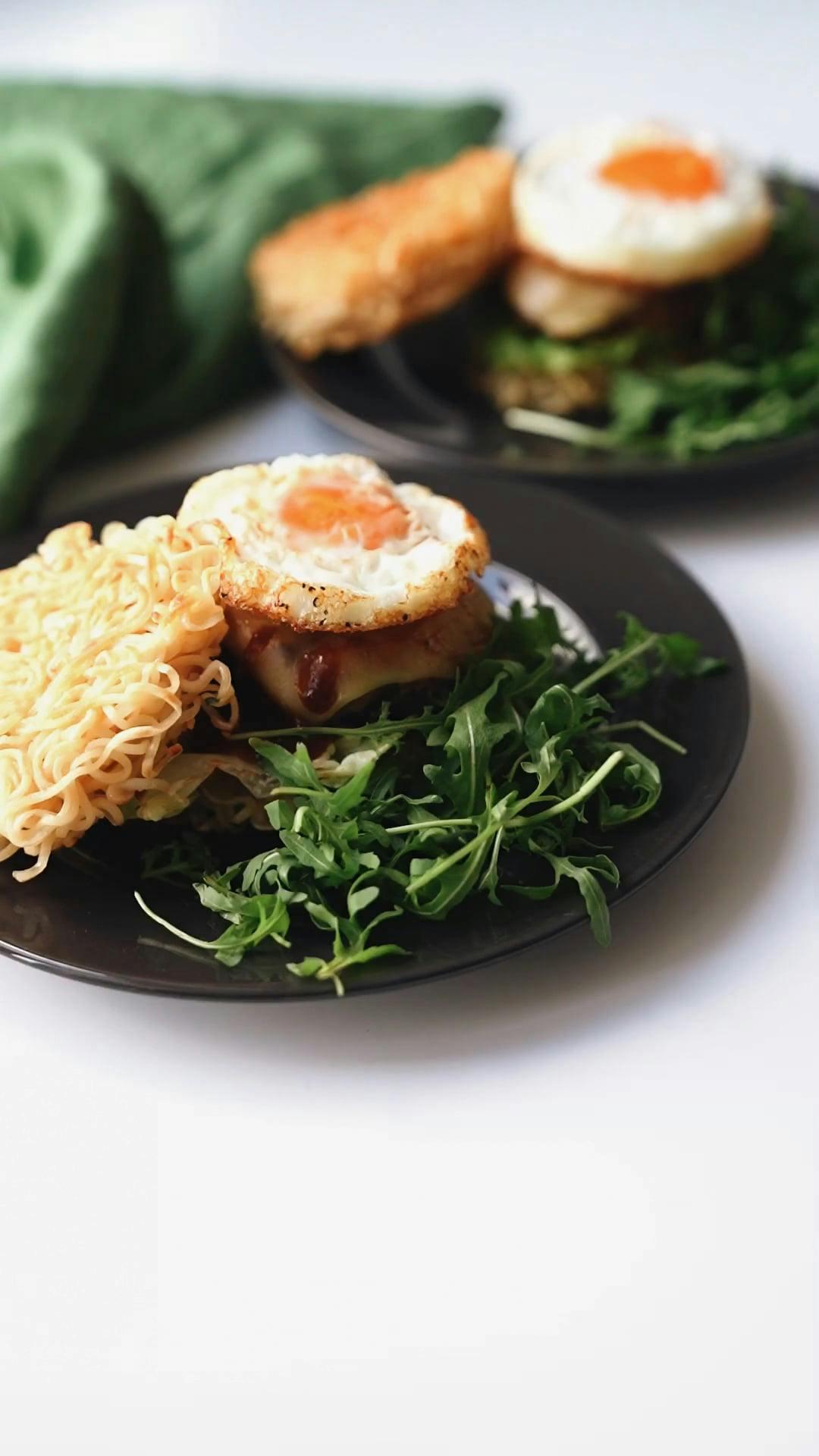 Close-up shot of a ramen burger with pickled vegetables, showing the texture and detail