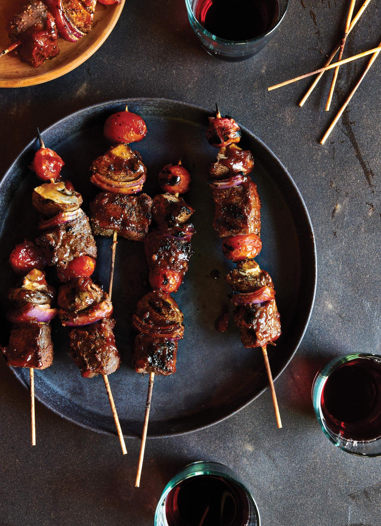 Close-up shot of juicy beef kebabs glistening with red wine reduction