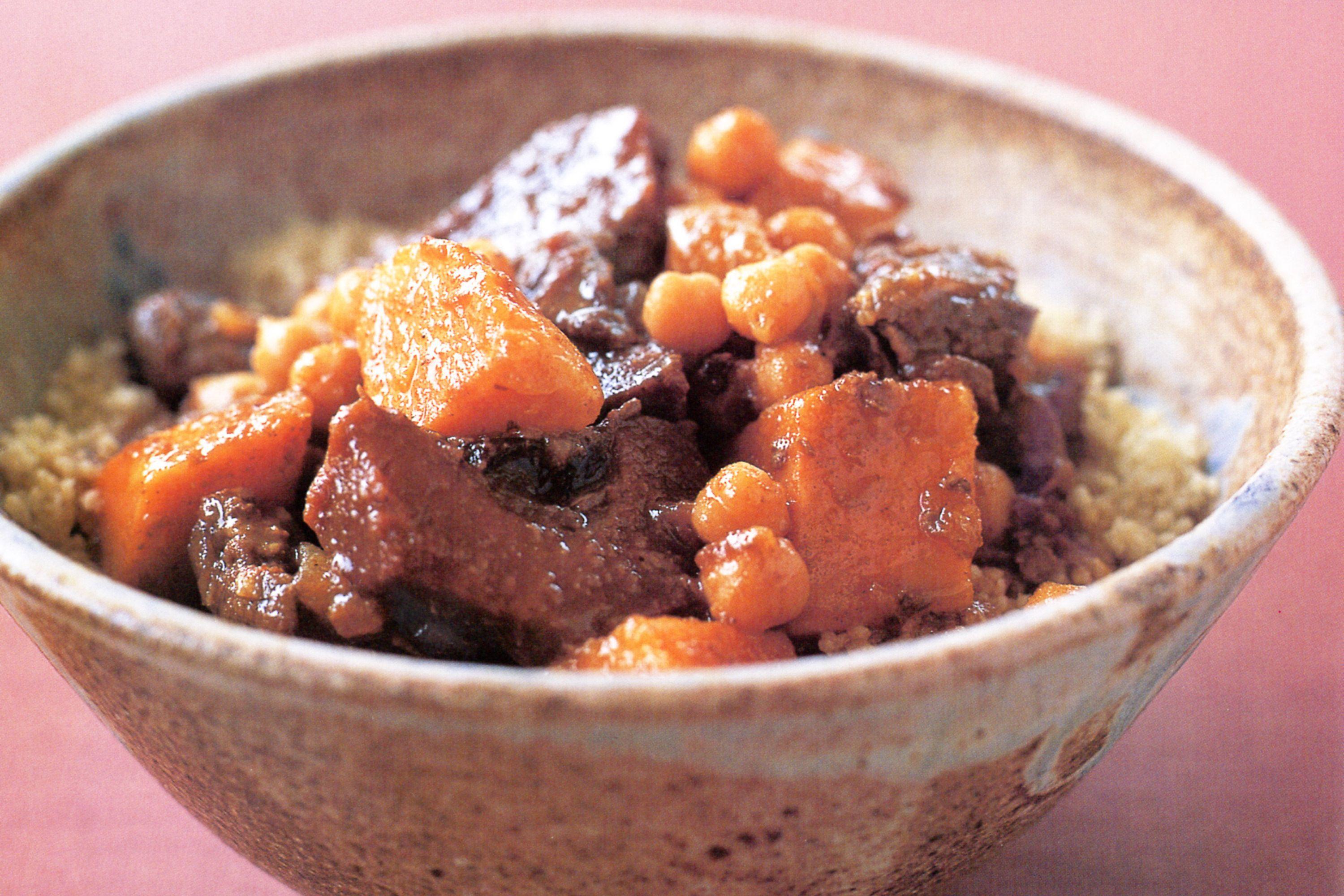Close-up shot of the tender lamb and quince in the tagine, highlighting the rich sauce and texture
