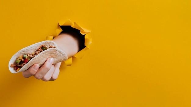 close-up of a hand grabbing a taco slider