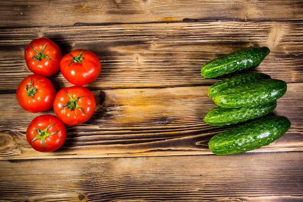 fresh tomatoes and cucumbers on a wooden table