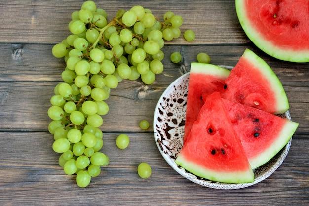 Assortment of fresh melon and green grapes on a cutting board