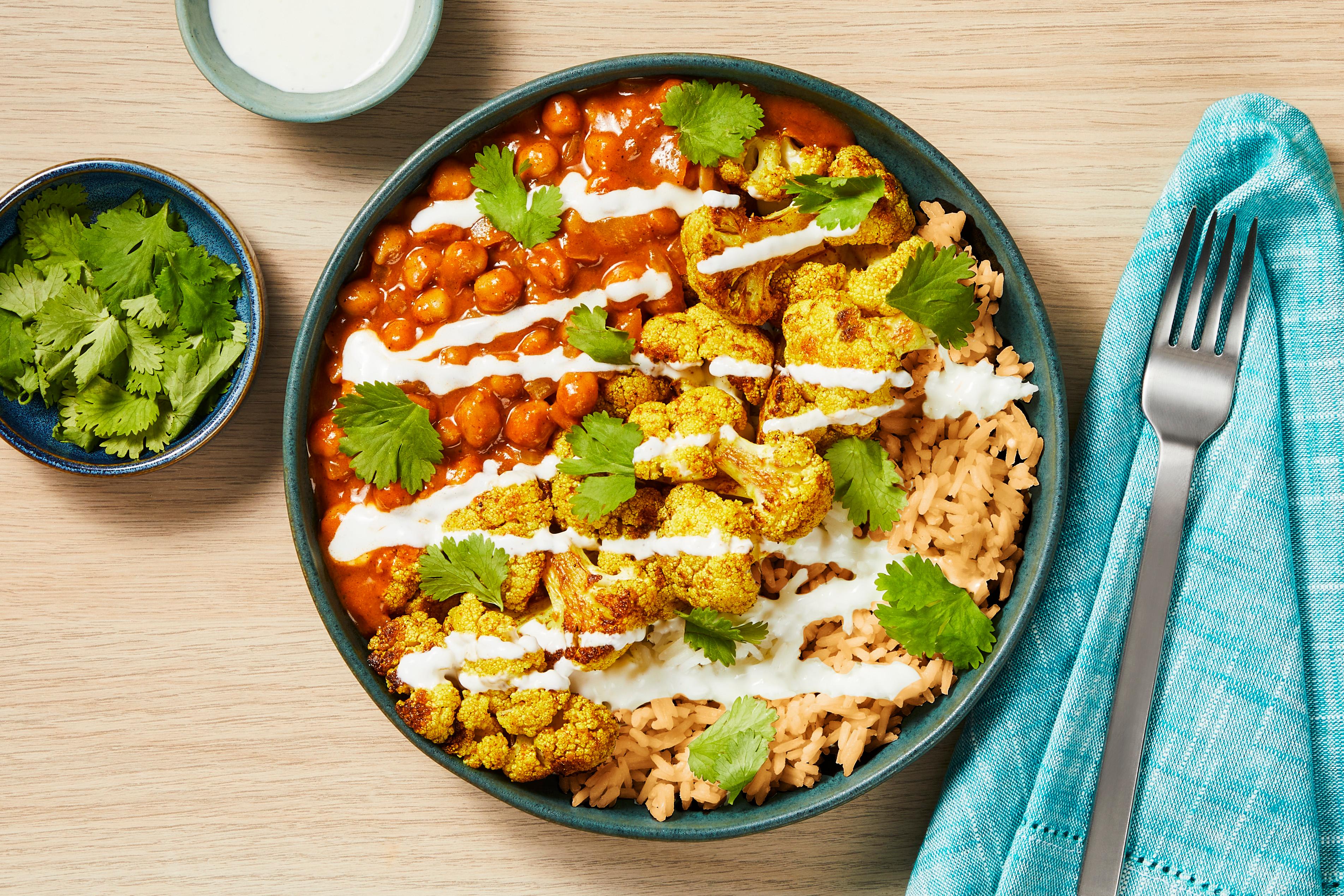 Close-up shot of a single curried cauliflower and chickpea bowl, showing texture and color