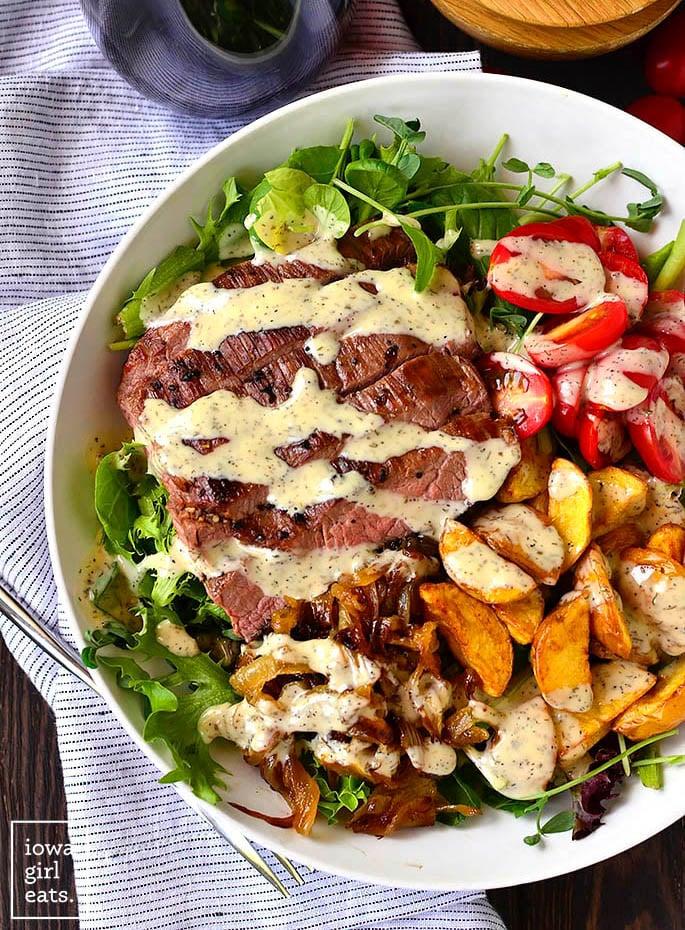 Overhead shot of a plated meal: steak, roasted potatoes, and a side salad