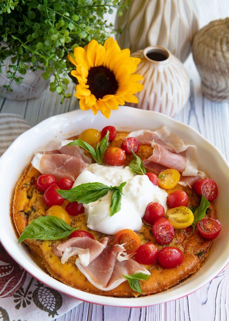 Ingredients for cherry tomato and burrata frittata laid out on a wooden countertop