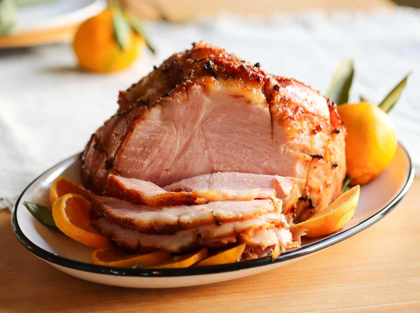 A beautifully carved honey garlic and ginger glazed Christmas ham on a serving platter