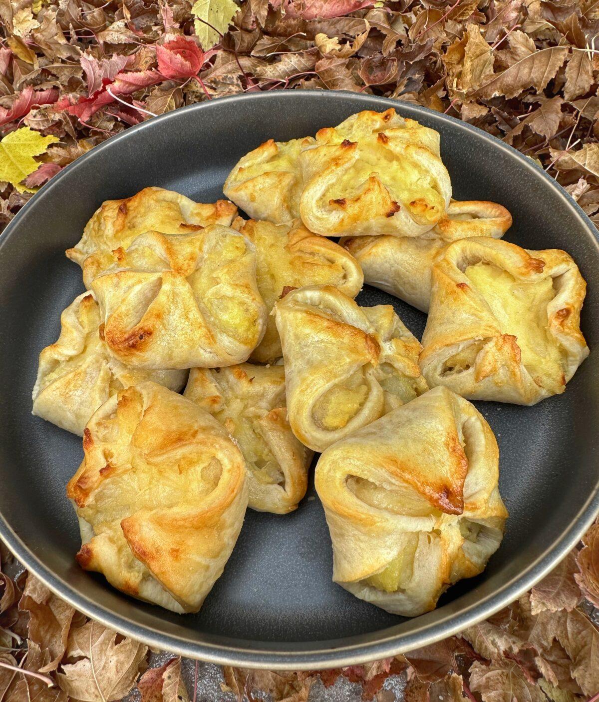 Close-up of freshly baked potato and cheese knish dumplings on a baking sheet