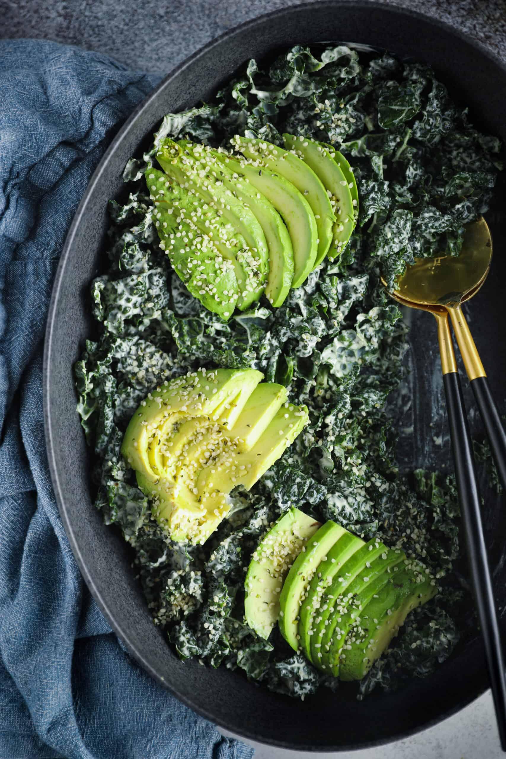 Close-up of a bowl of avocado kale salad with cashew cream dressing