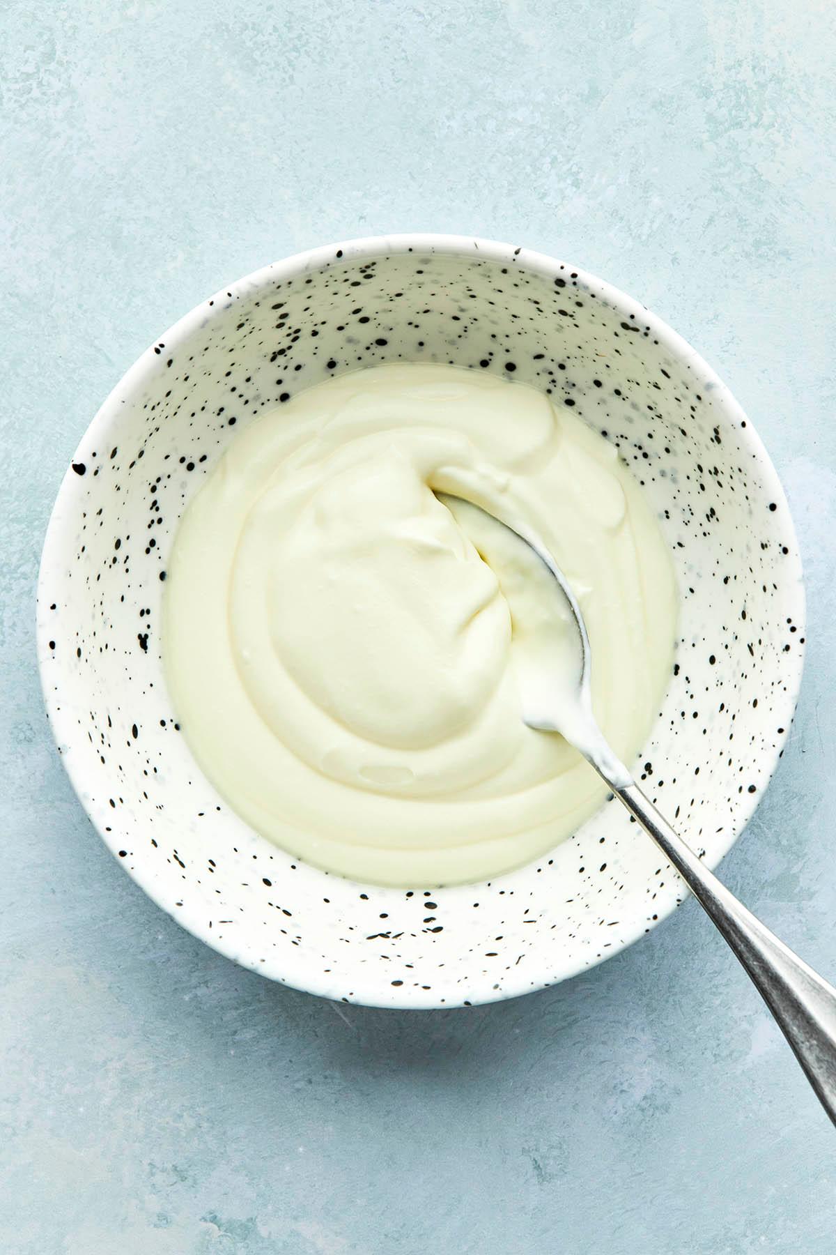 A bowl of crème fraîche with a spoon.