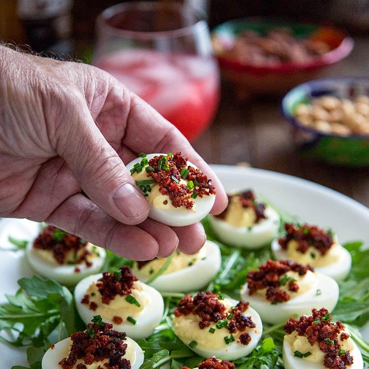 Close-up shot of spicy chorizo and manchego deviled eggs garnished with fresh parsley
