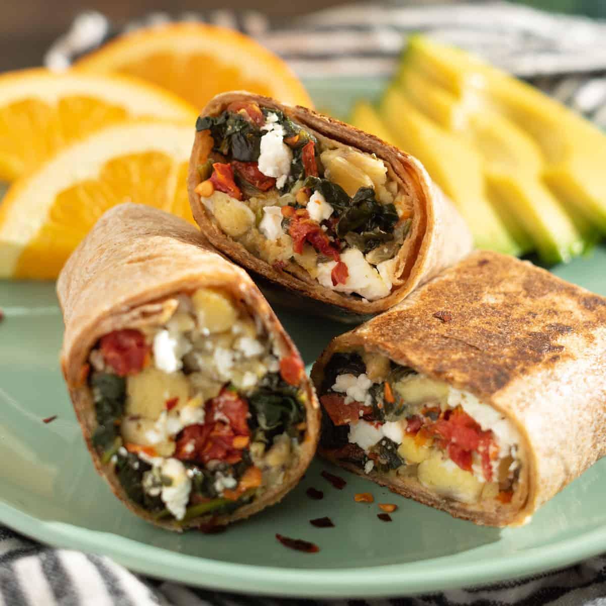 Close-up shot of a Falafel Breakfast Burrito with Feta and Spinach, cut in half to show the filling