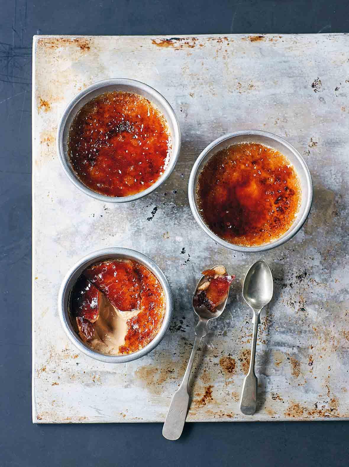 Close-up shot of chai crème brûlée ramekins with caramelized sugar topping, steam rising