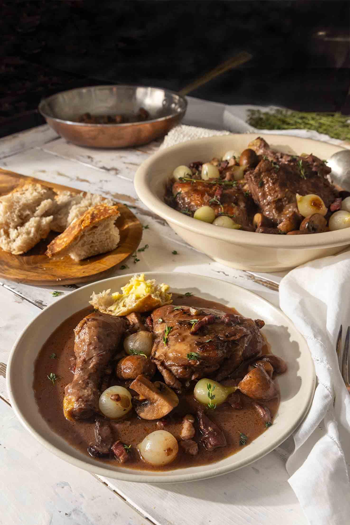 Close-up of a plate of Coq au Vin with Fontina cheese, showing the texture and richness of the sauce
