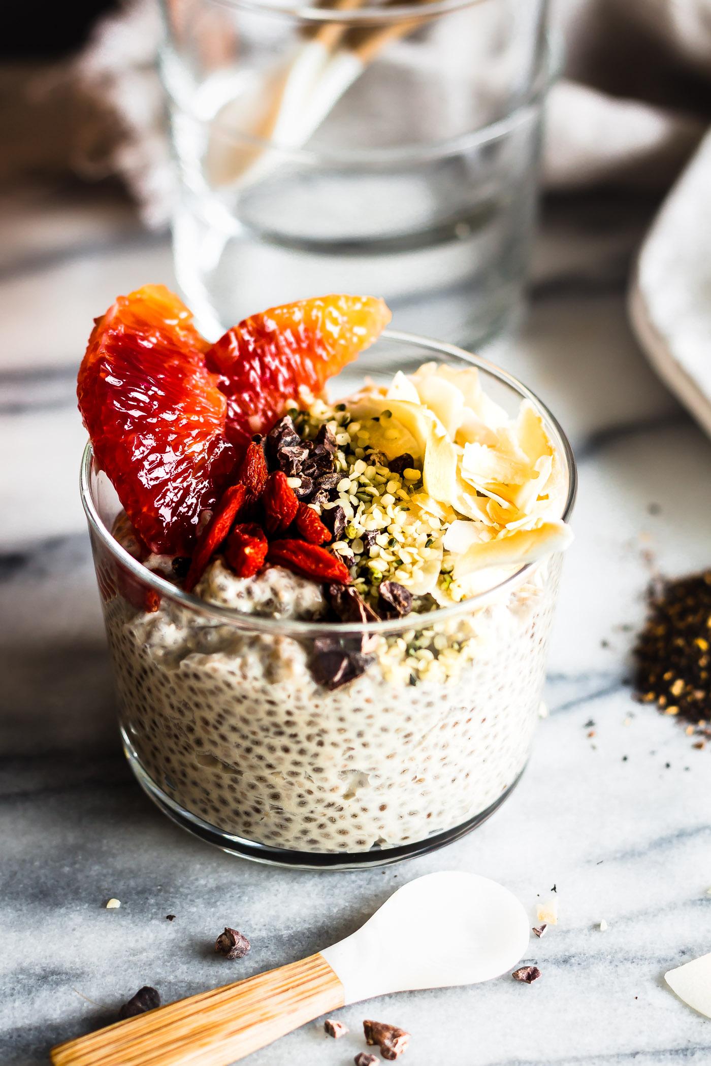 A creamy, layered chai tea chia seed pudding with cardamom, garnished with fresh berries and nuts.
