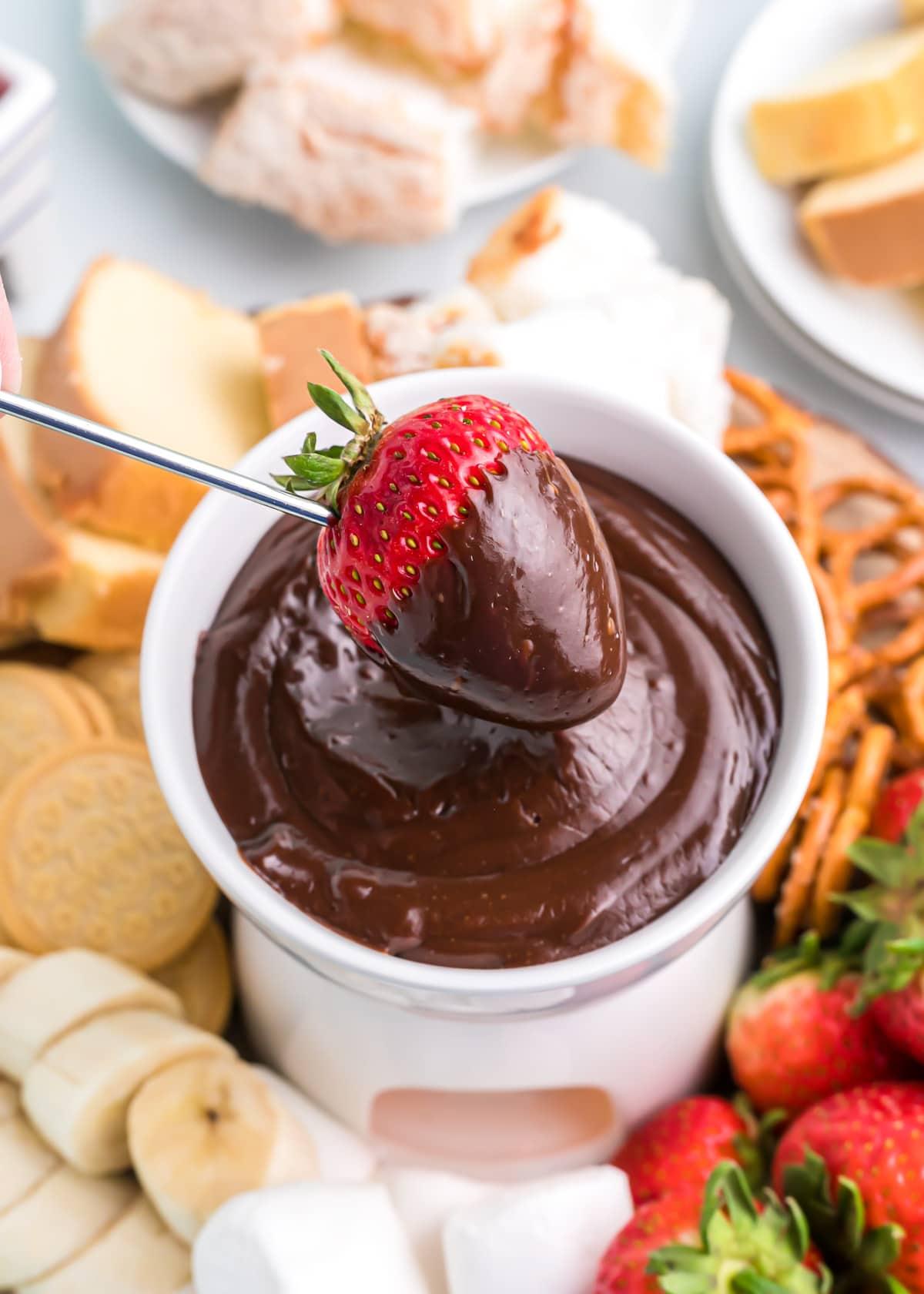 Close-up shot of a decadent Key Lime Chocolate Fondue with various dipping options, such as strawberries, pound cake, and cookies.