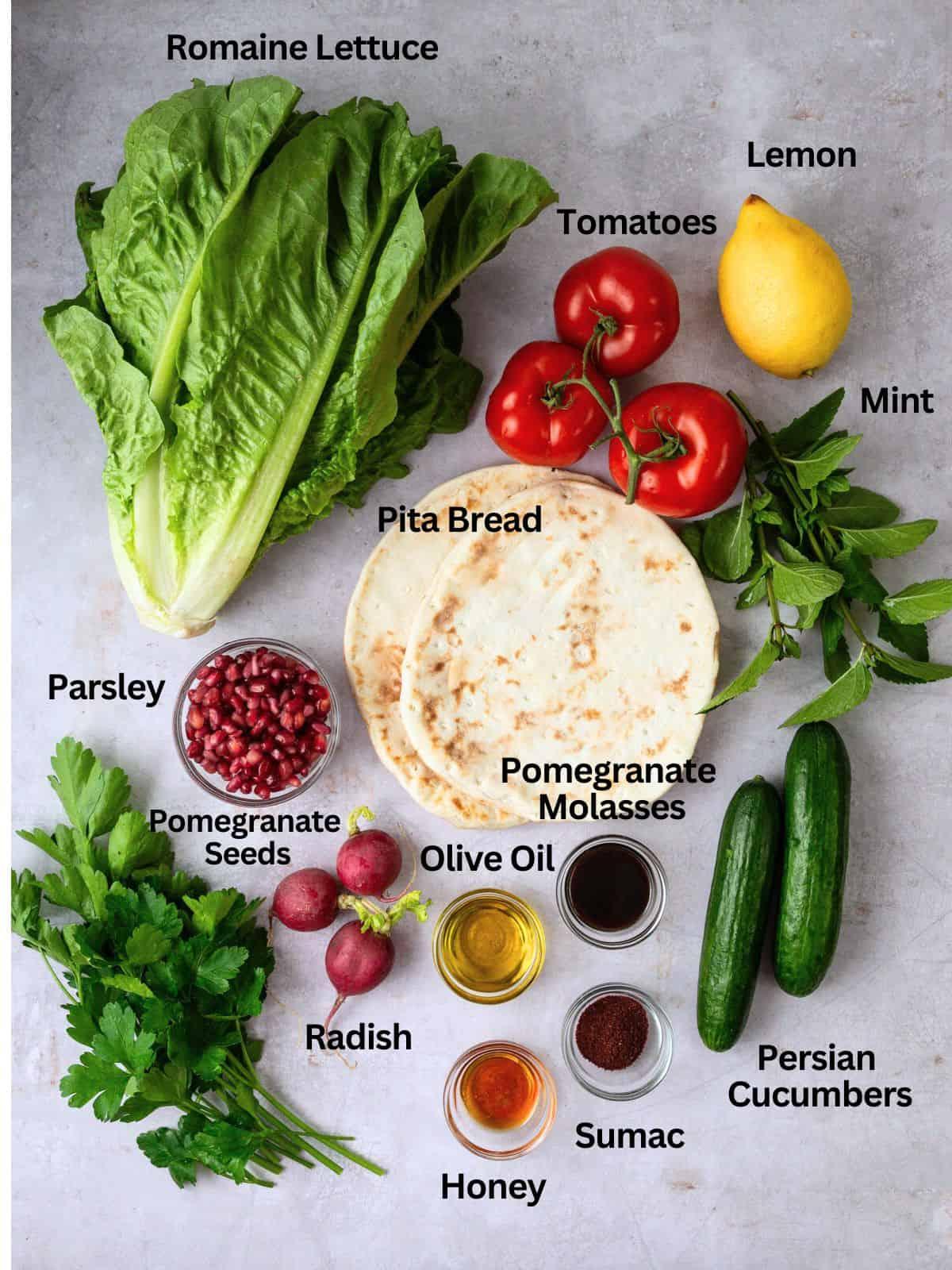 Close-up shot of ingredients for Fattoush salad, including fresh lettuce, tomatoes, cucumbers, and pomegranate seeds