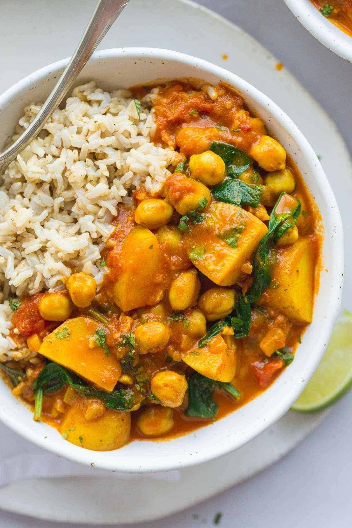 Close-up shot of a bowl of chickpea and potato curry with rice