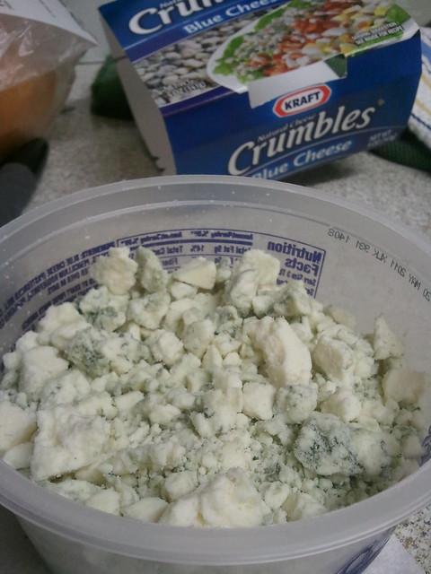 A close up of the blue cheese crumbling onto the poke bowl.