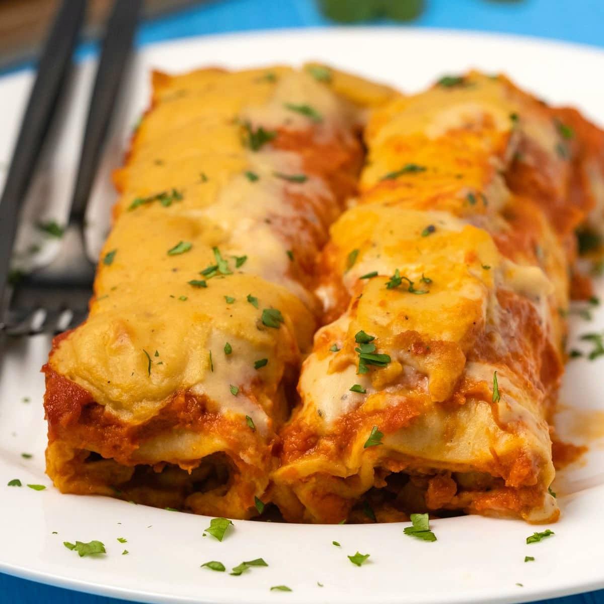person serving vegan mac and cheese enchiladas on a plate
