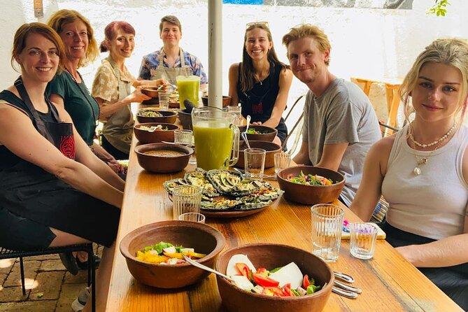 A table with several small bowls of ceviche surrounded by people who look happy