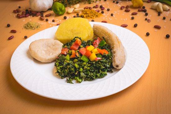 Close-up of a Callaloo and Ground Provision Bake, showing the layers of callaloo and provisions