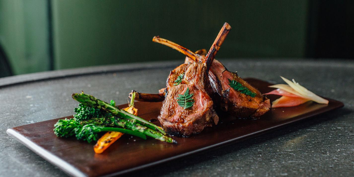 finished lamb chops with callaloo on a plate, garnished