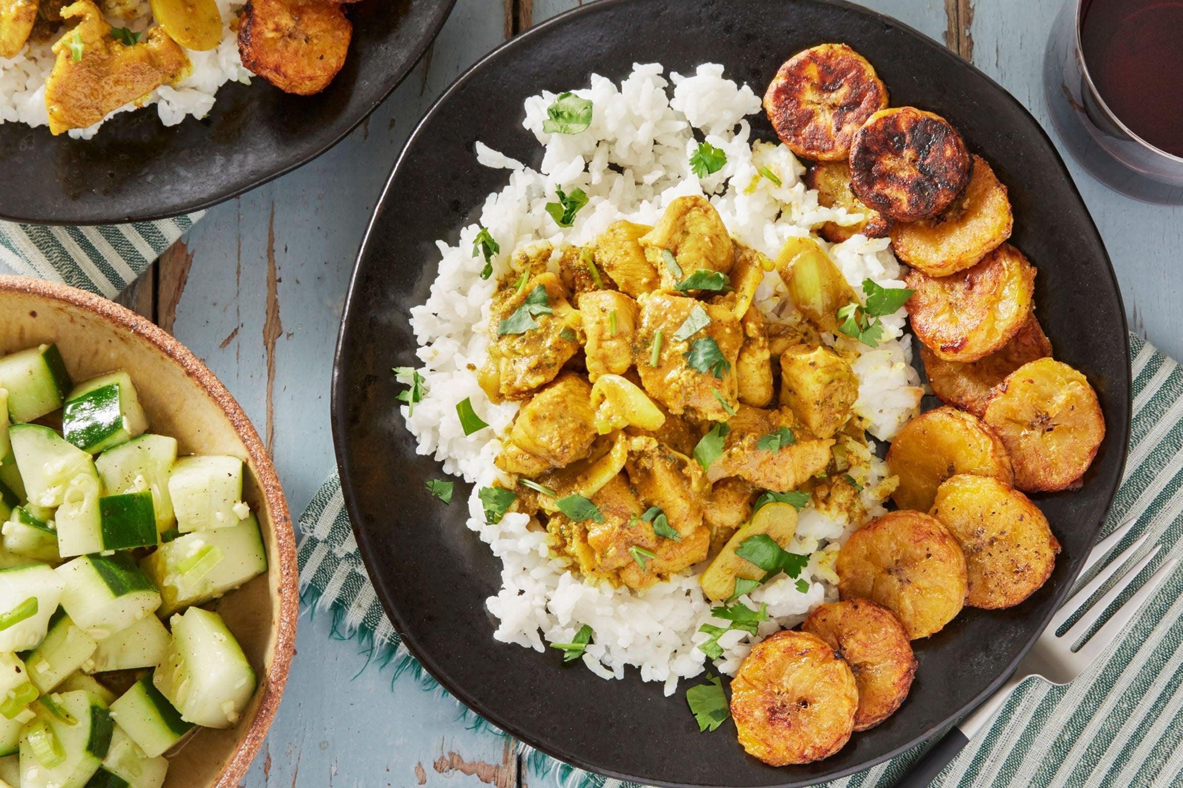 A vibrant photo of Caribbean Plantain and Coconut Curry served in a bowl, garnished with fresh cilantro and lime wedges.