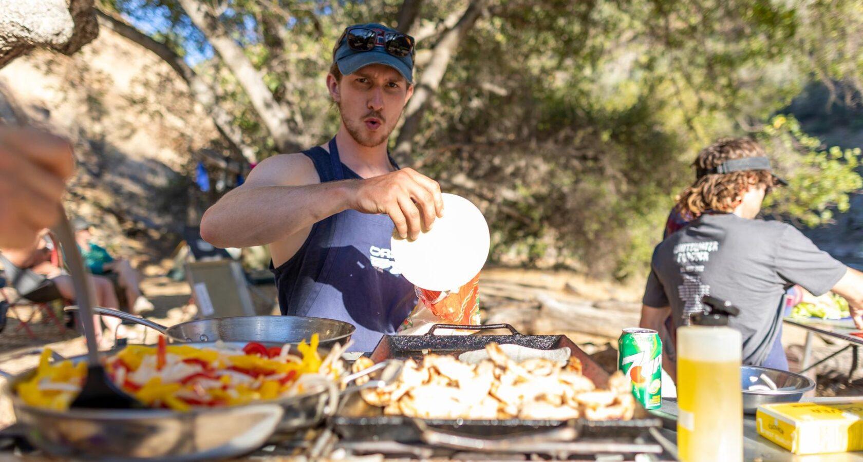 A group of friends enjoying a meal outdoors, featuring a bowl of boiled rice with mushrooms and thyme.