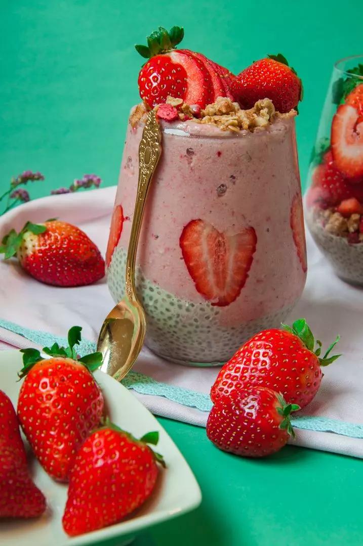 Person enjoying a strawberry chia seed smoothie outdoors