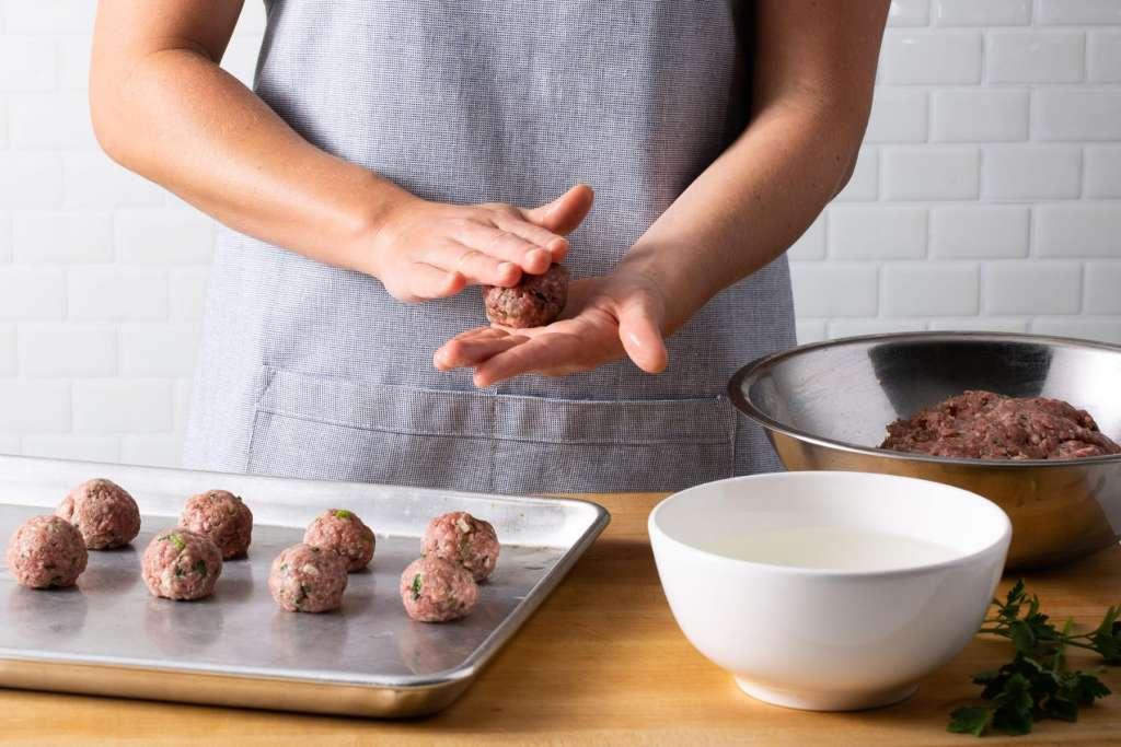 Close-up shot of someone's hands mixing the plant-based meatball ingredients in a bowl