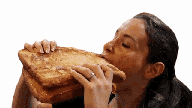 A person taking a bite of a Gravy Gourmet Grilled Cheese, with a contented expression