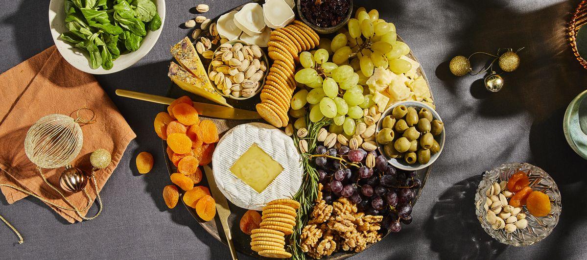 Overhead shot of a fully assembled charcuterie board with a central baked camembert, ready to serve