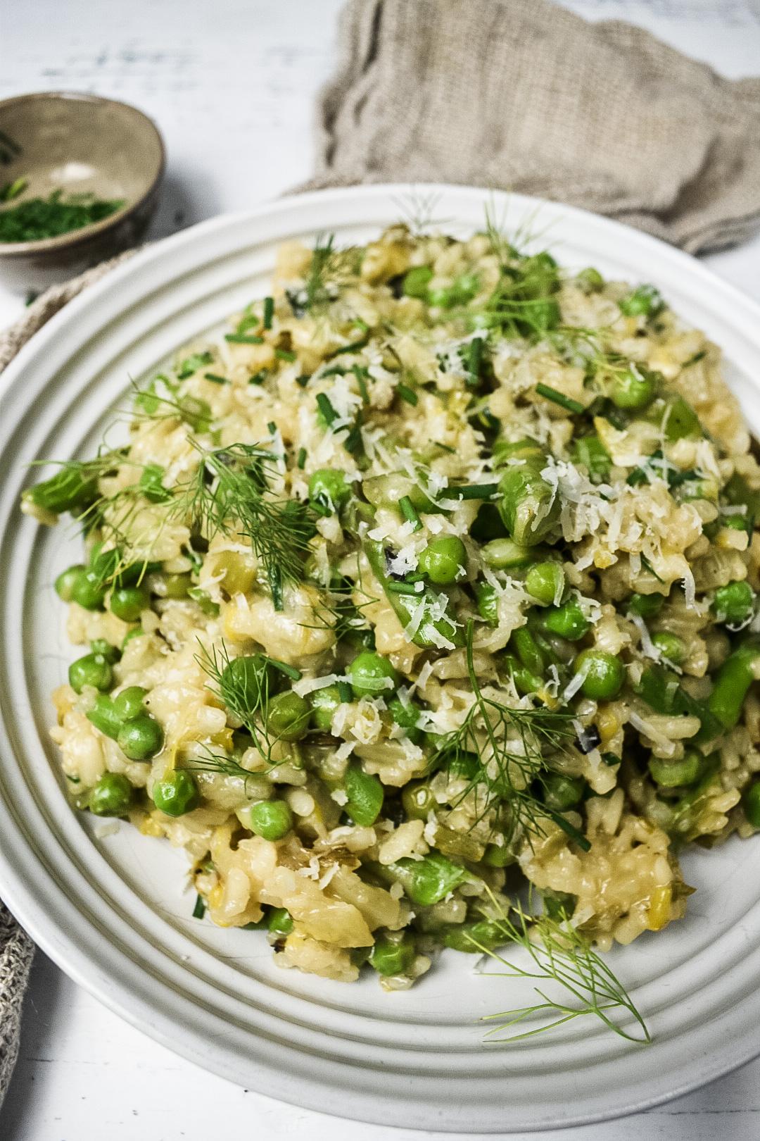 A vibrant, creamy risotto with wilted spinach and creamy ricotta cheese, garnished with fresh herbs