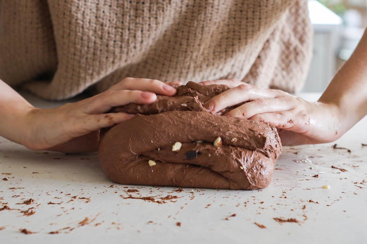hands kneading chocolate sourdough dough