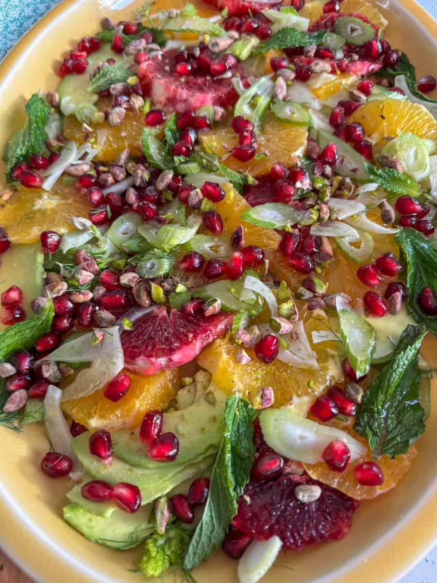 close up shot of pomelo pomegranate salad with feta, mint garnish