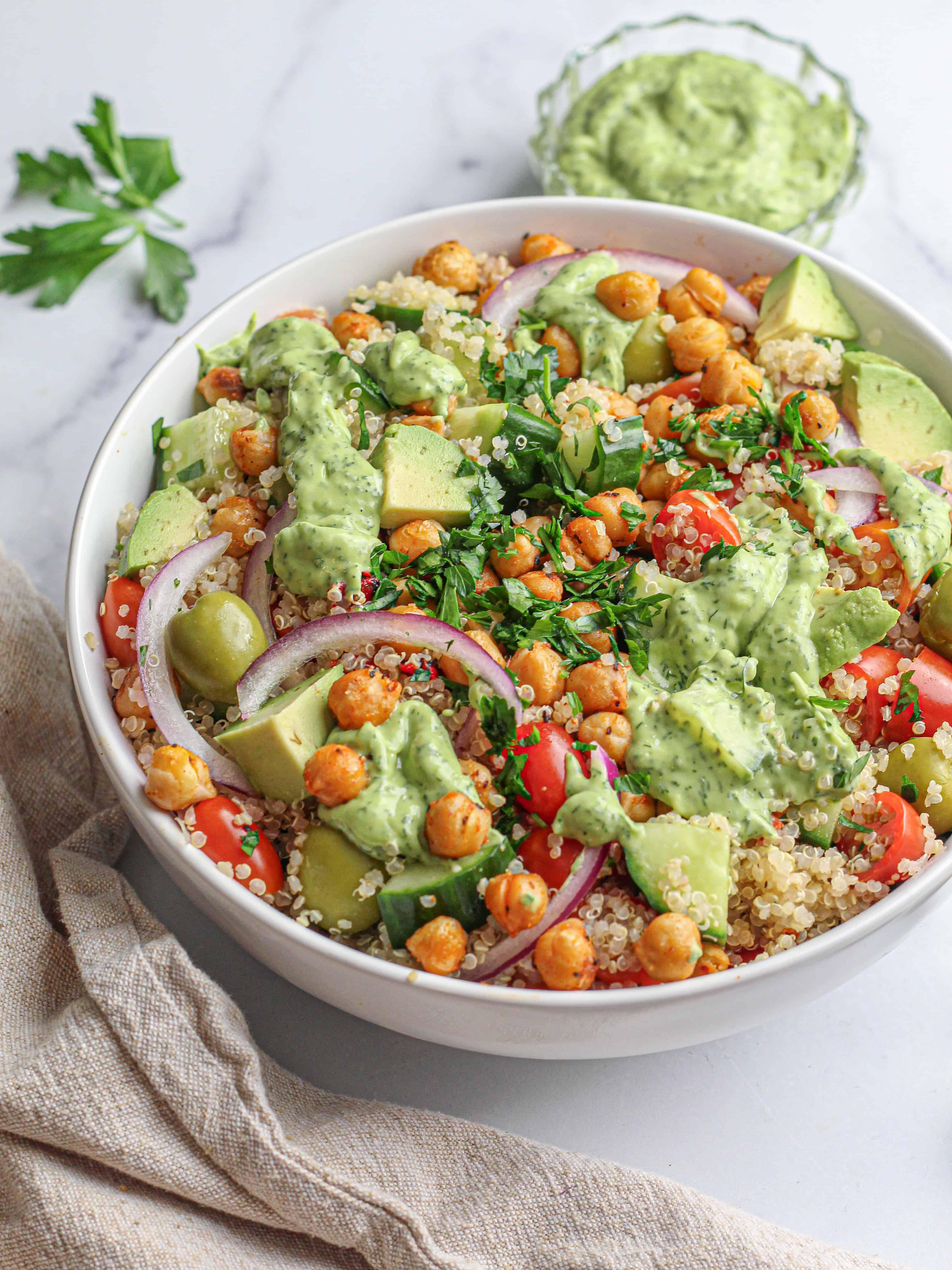 Close-up shot of a bowl of quinoa salad with creamy avocado dressing, showing the texture and ingredients.
