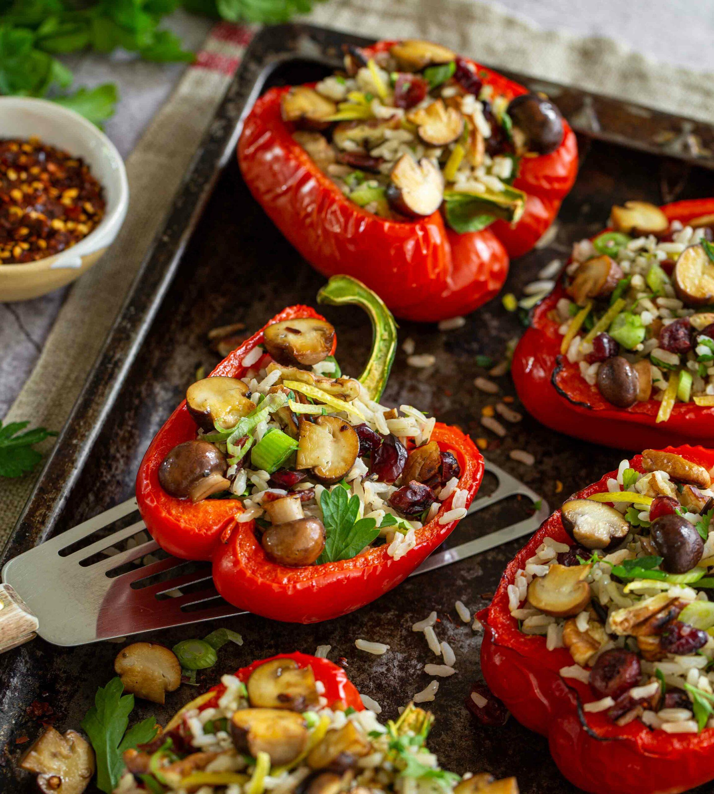 Close-up shot of vibrant stuffed bell peppers with wild rice and cranberries, garnished with fresh herbs